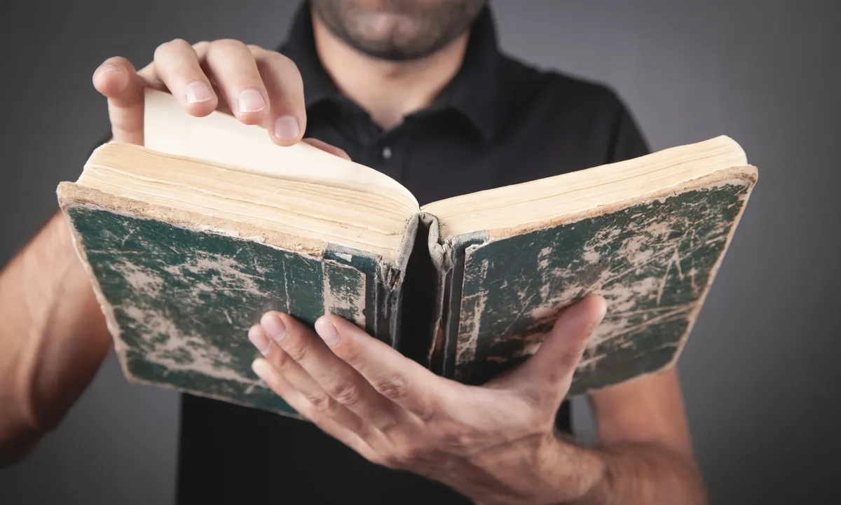 Történelem kvízre készülő férfi könyvet tartva a kezében