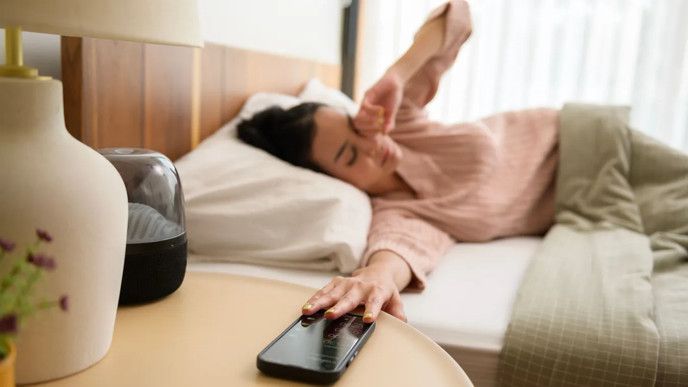 Ébresztőóra jelzése miatt a telefonjához nyúló nő reggel