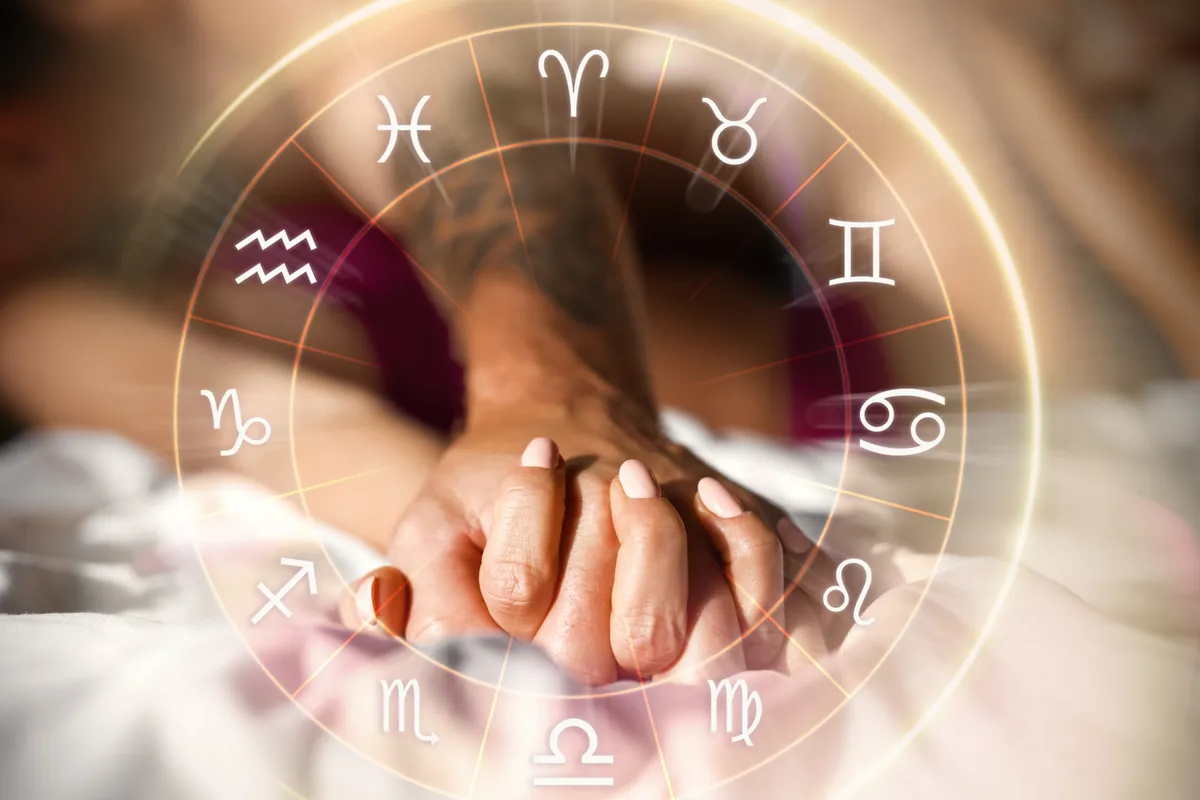egy pár összekulcsolt keze az ágyon, eelőtérben a zodiákus horoszkóp jegyei