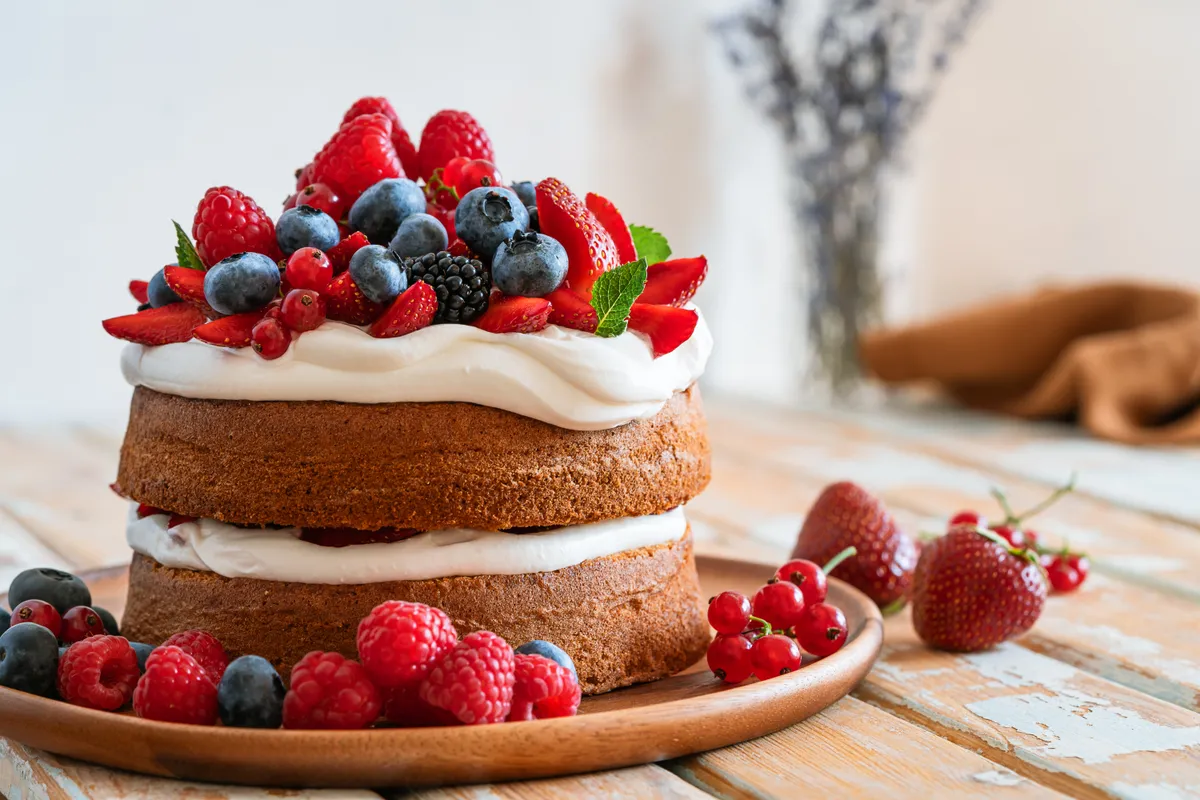 Mennyei piskótatészta krémmel és gyümölcsökkel díszítve.