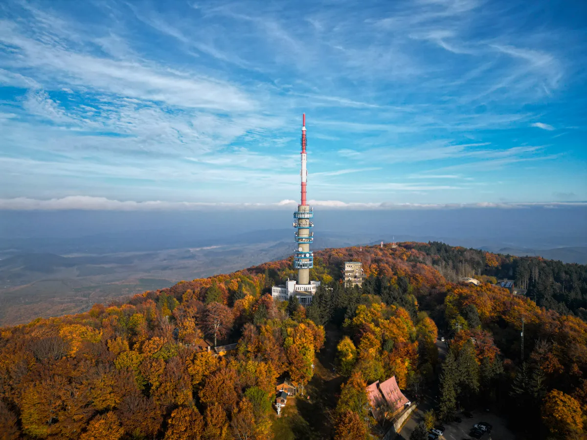 A Kékestetőn álló televízós torony őszi erdővel körülvéve.