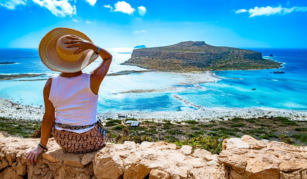 A tökéletes nyaralás: egy nő gyöyörködik a tengerparti tájban.