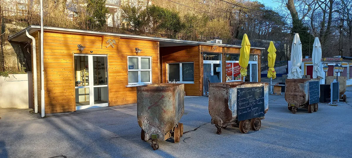 A hinterbrühli tavas barlang bejárata, amelyet régi bányakocsik díszítnek.