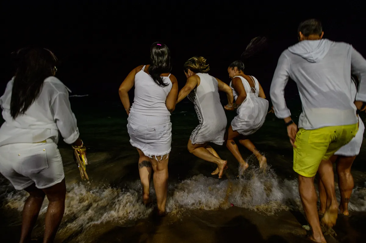 Braziliai fiatalok fehér ruhában a vízben az újévi szokásnak megfelelően