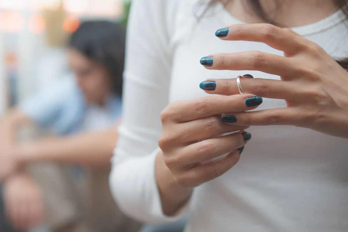 Eljegyzési gyűrűjét lehúzó nő a horoszkópban.