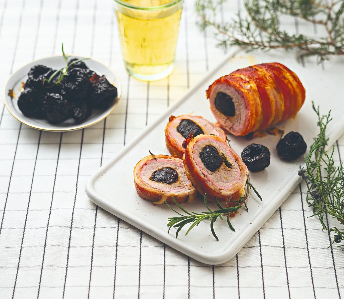 Az egyszerű karácsonyi menü elengdhetetlen összetevője az aszalt szilváva töltött, baconbe tekert sertésszűz látható, szépen tálalva.
