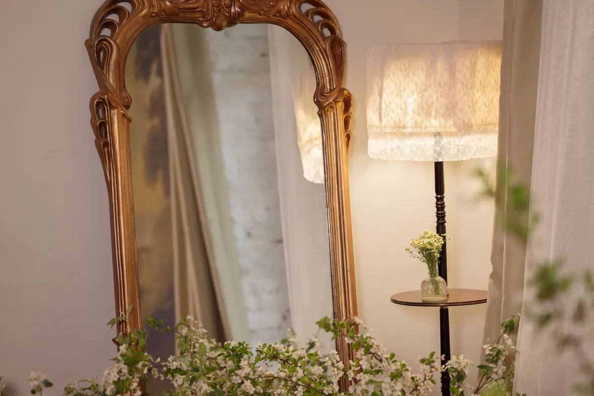 Szerencsehozó tárgyak közül egy tükör az ágy mellett.