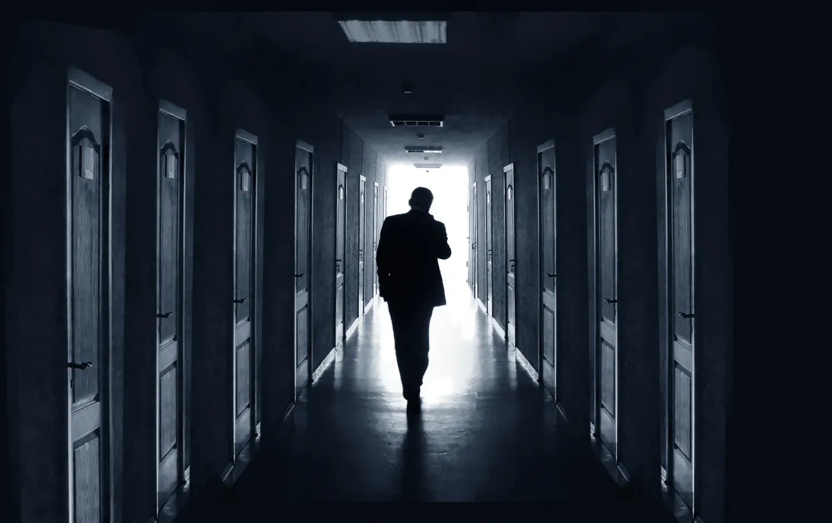Sötét folyosón sétáló férfi a személyiségtesztben.
