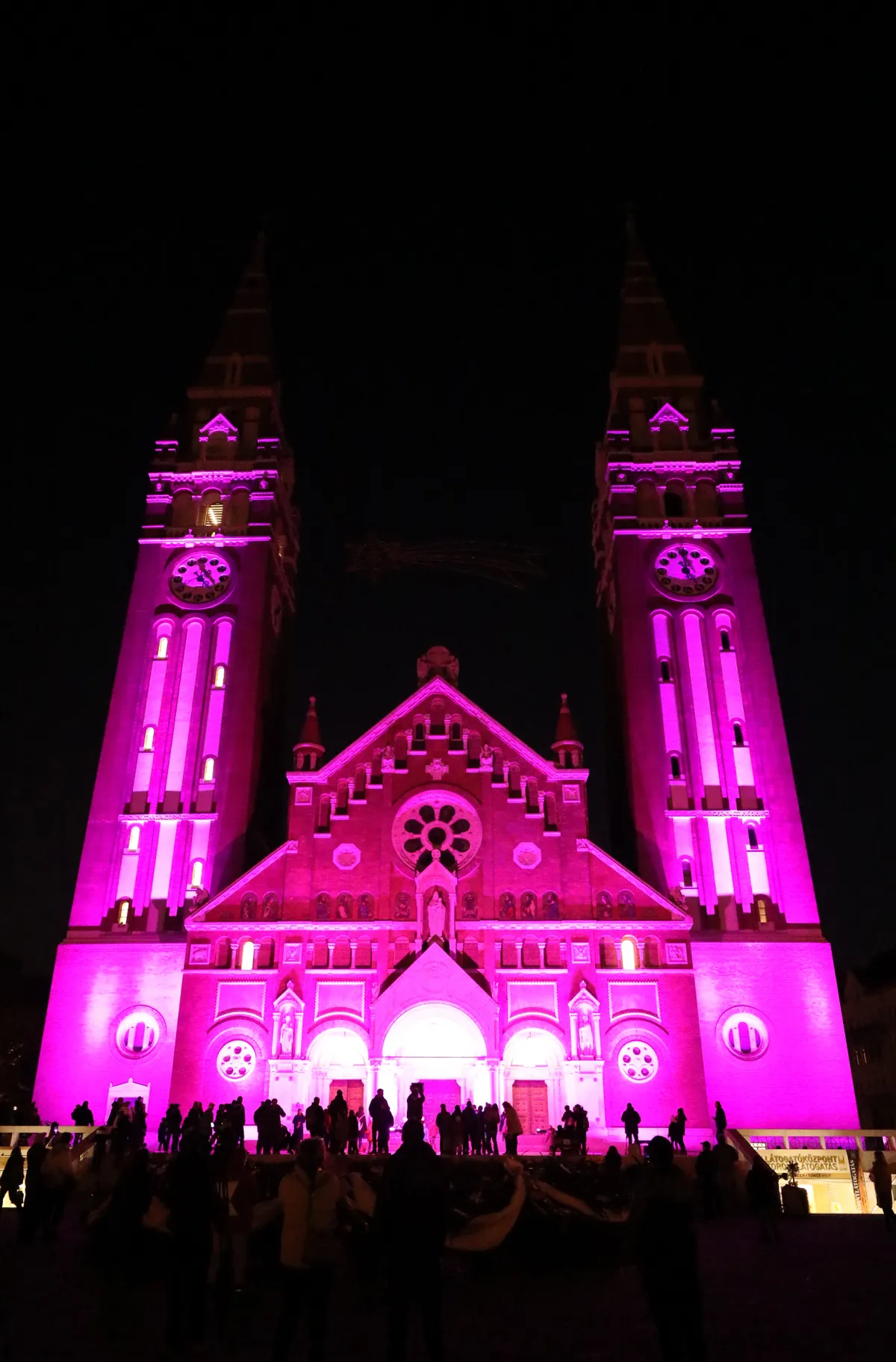 Emberekből álló tömeg nézi a Szegedi Dóm falára vetített fényfestést.