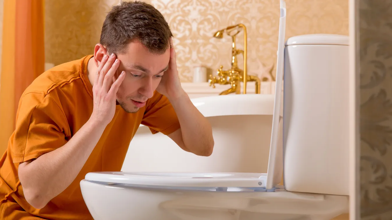 Széklet színe miatt aggódó férfi a vécé fölé hajolva