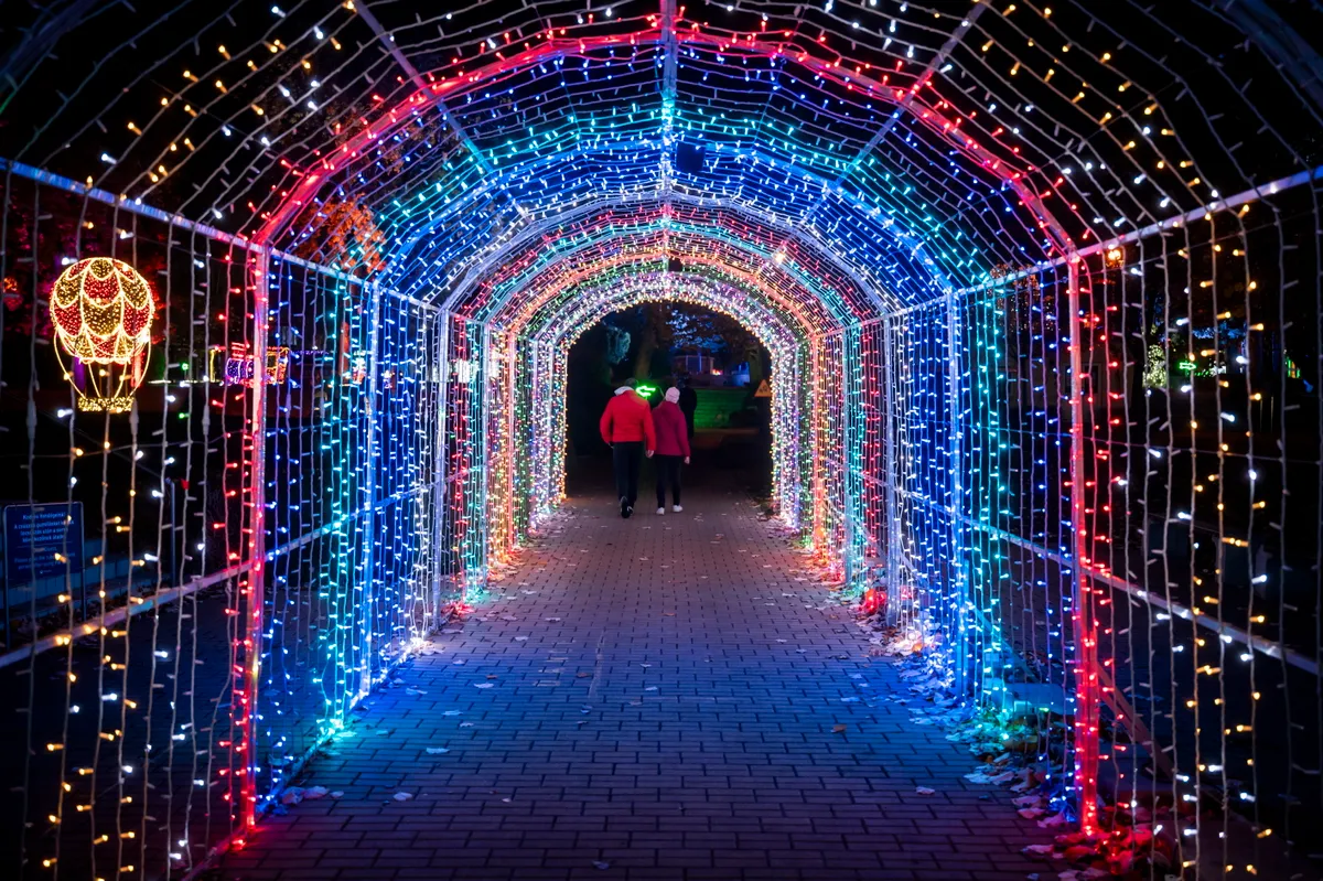 Fényfolyosón halad át egy pár a Lumina parkban.