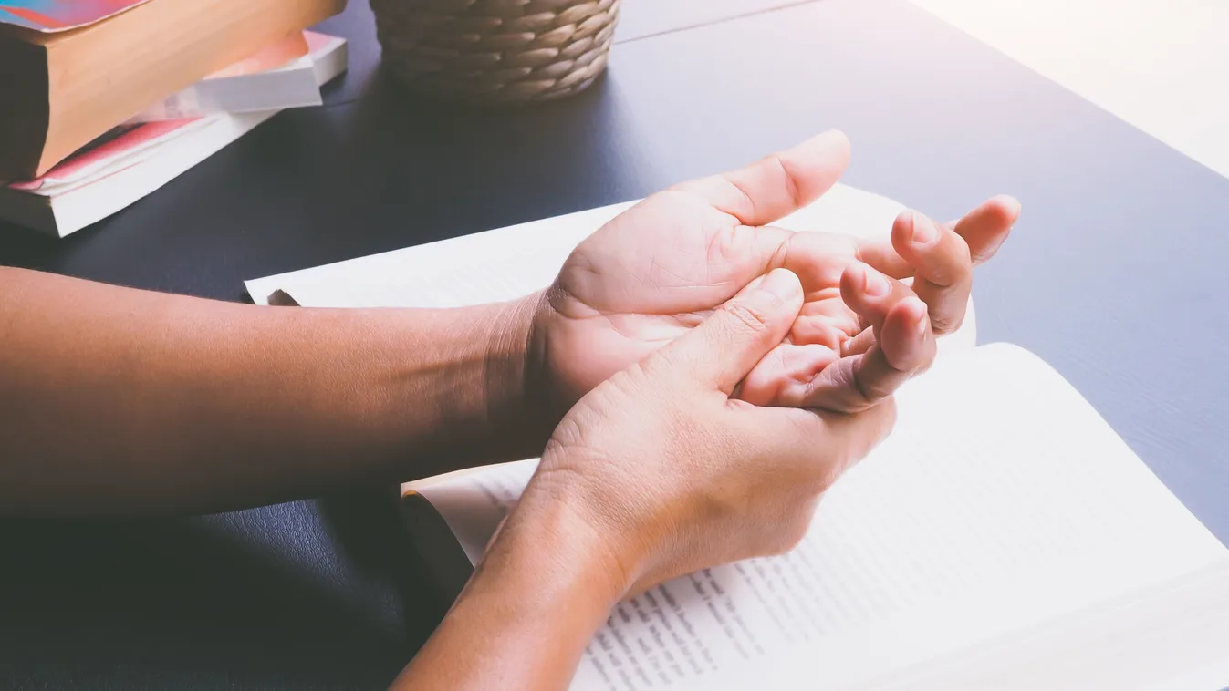 Fokozott nyáltermelést és kézmerevedést okozó motoros neuronbetegségben szenvedő férfi a bal kezét fogja