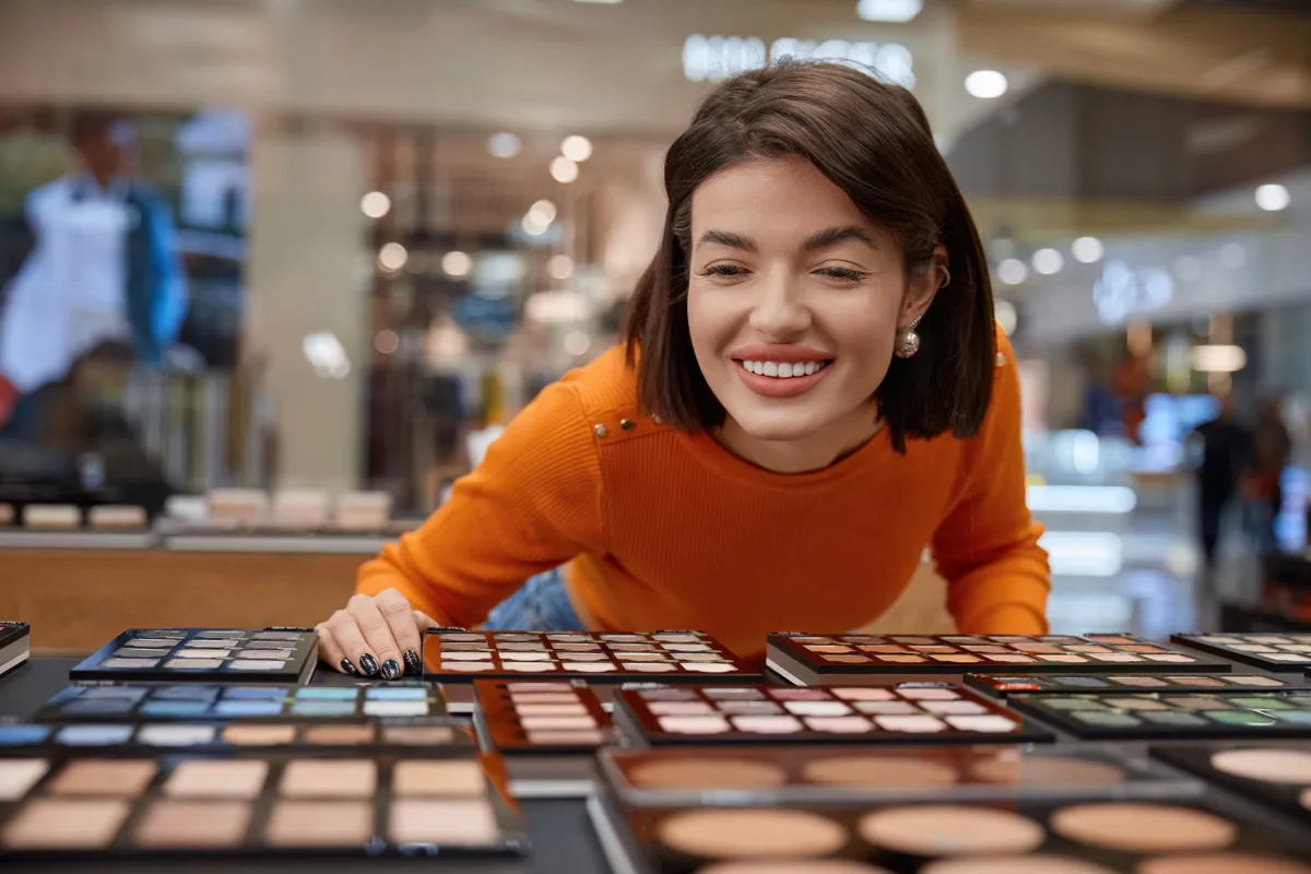 Egy nő épp a szemhéjpalettákat nézi, sminktippjeink alapján választja ki a befutót, amit megvásárol.