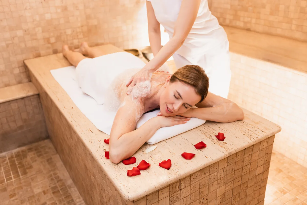 Egy fiatal nőt masszíroznak a törökfürdőkben.