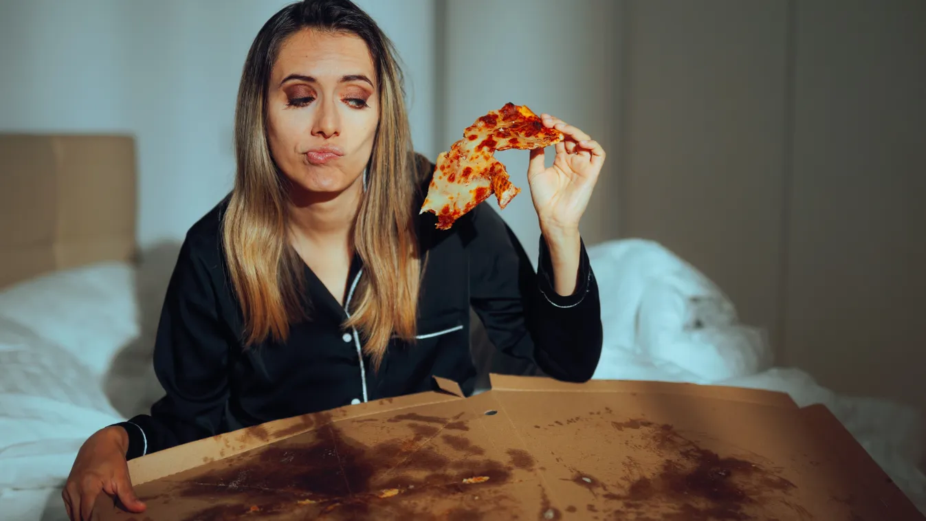 Pizzát, a boldogtalanító ételek egyikét fogyasztó nő