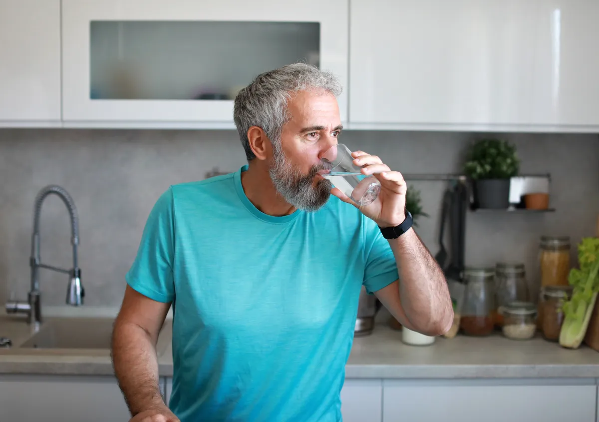 A vesekárosító szokásaival leszámoló férfi, aki éppen vizet iszik.