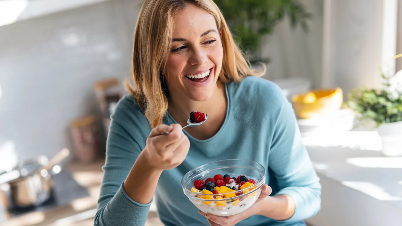 A mindful eatingre törekvő nő, akit boldogsággal tölt el az egészséges, finom müzli.