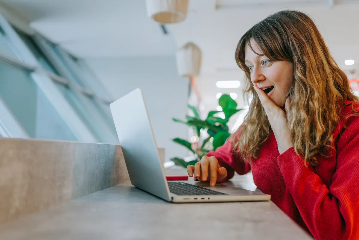 olcsó nyaralást foglal le az interneten a laptopján egy nő. 