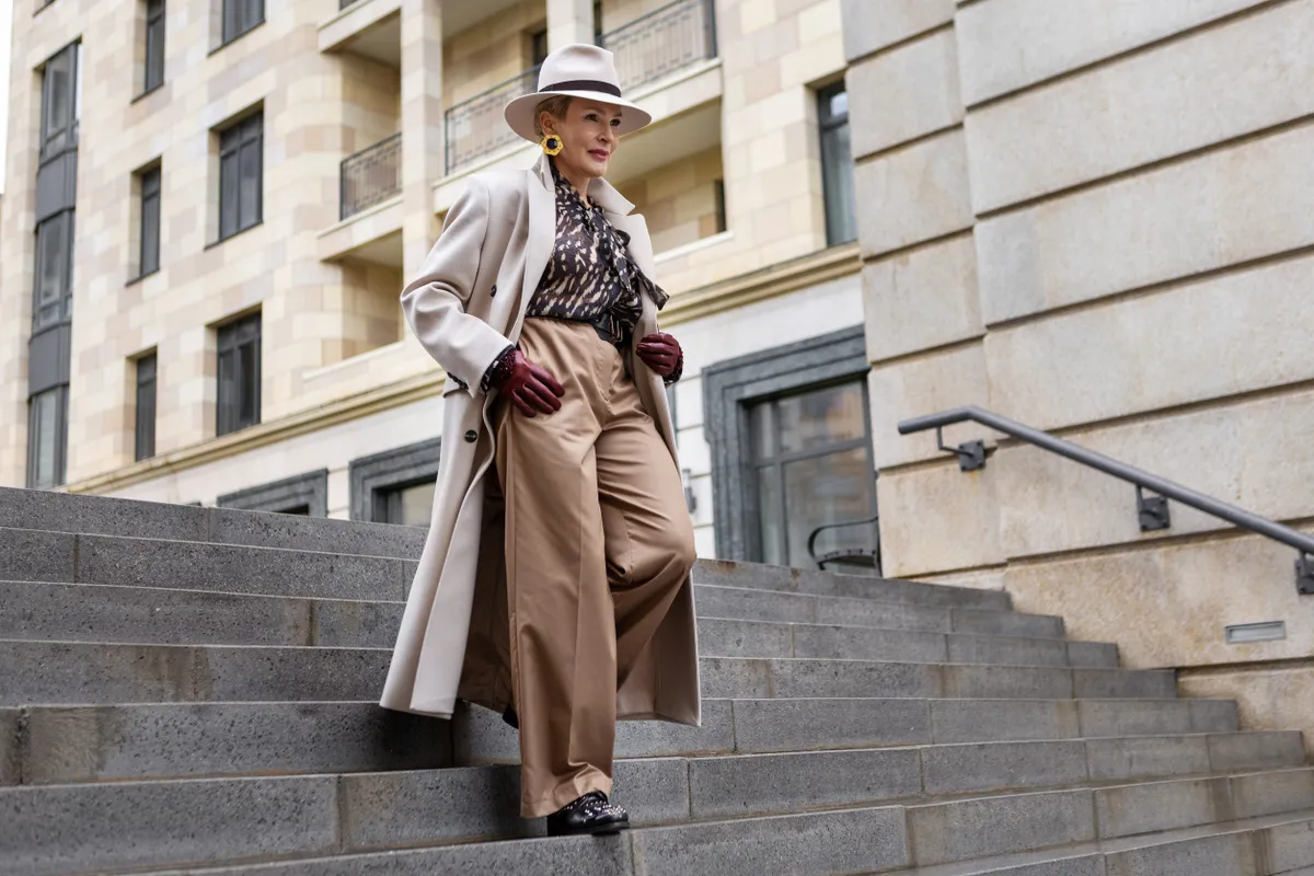 Stílusos nő egy divatos szettben sétál a lépcsőn.