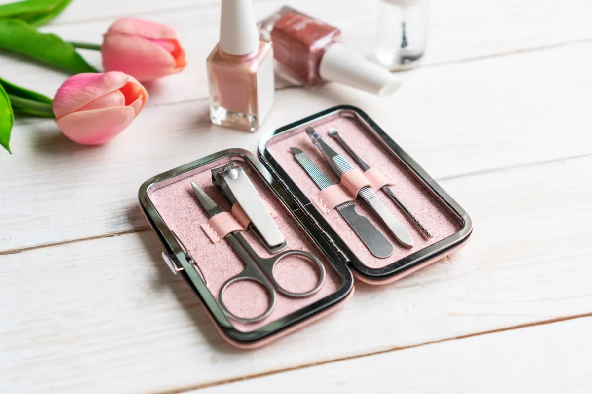 Manikűrkészlet körömlakkal és rózsaszín tulipánokkal.