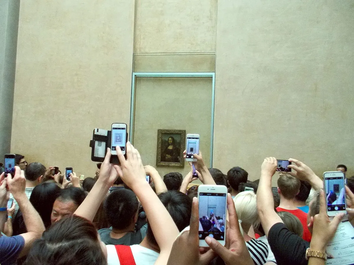 Turisták a Mona Lisa előtt a Louvre múzeumban