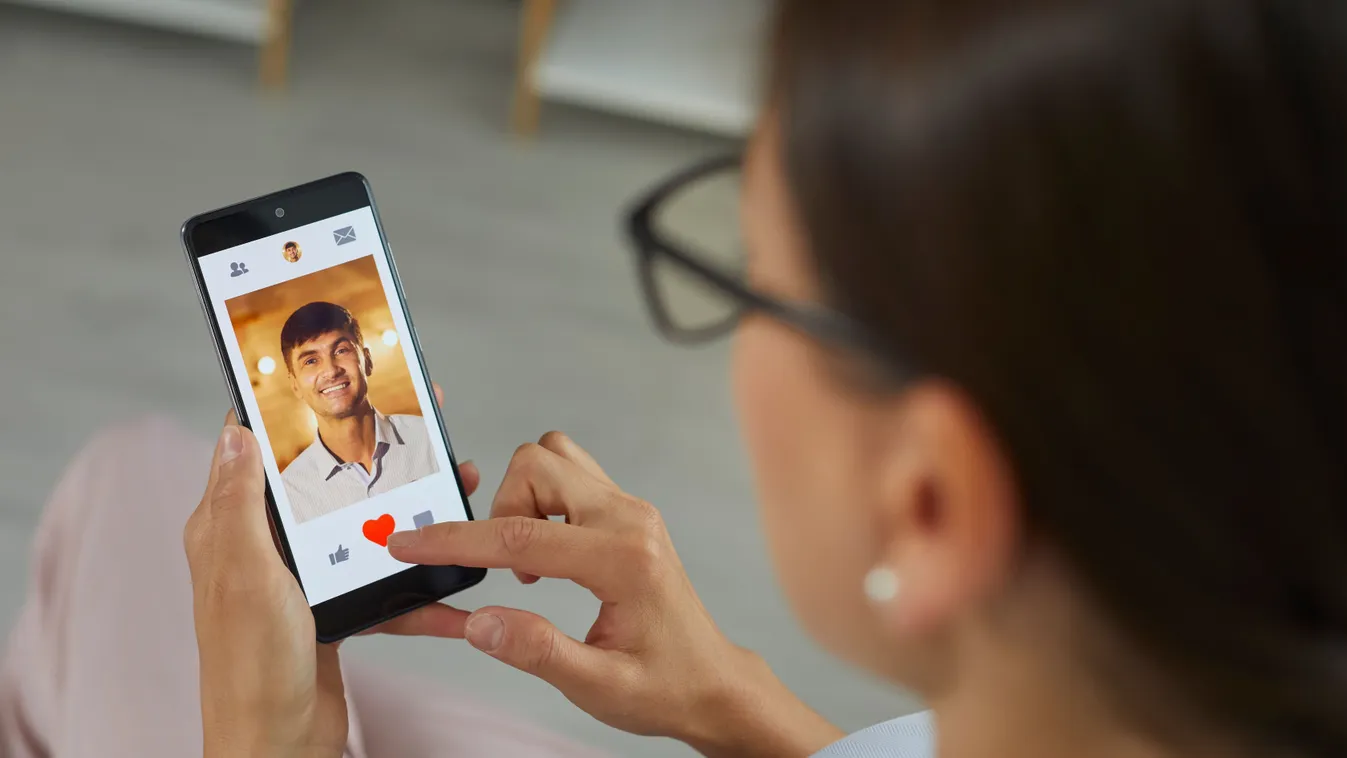 Társkeresőt görgető nő, aki a horoszkóp szerint mindenkinek ad egy esélyt.