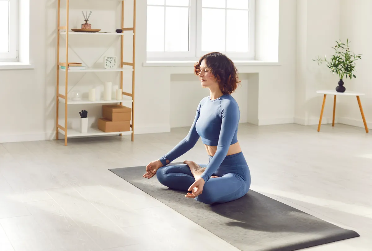 Fejfájás megelőzése érdekében otthon jógázó nő