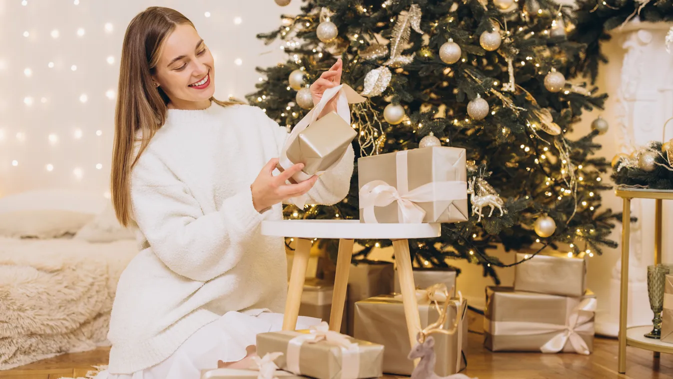 Személyiségtesztben szereplő kép egy karácsonyi ajándékokat bontogató fiatal nőről
