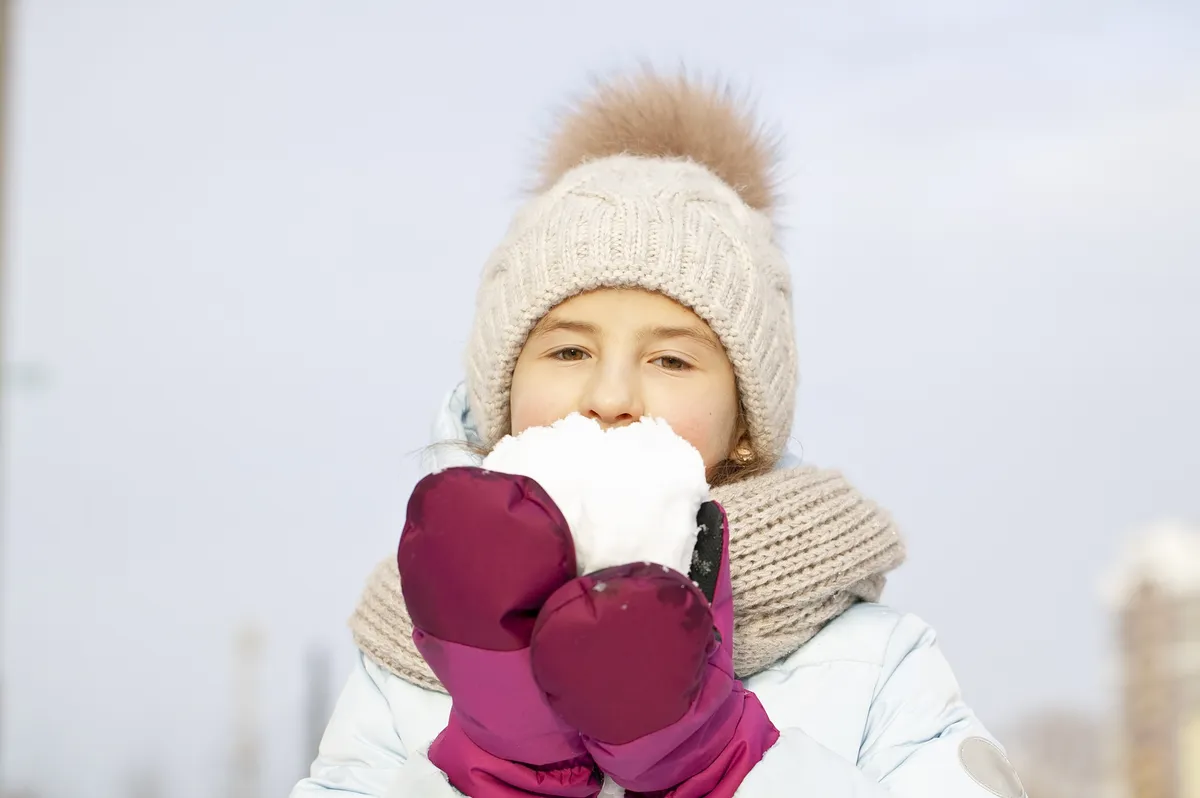 Egy gyerek épp a sima havat eszi ahelyett, hogy hófagyit csinálna.