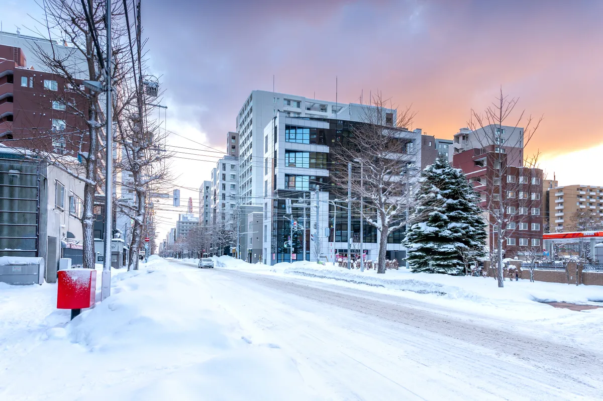 Sapporoi havas utcarészlet hóborította épületekkel.