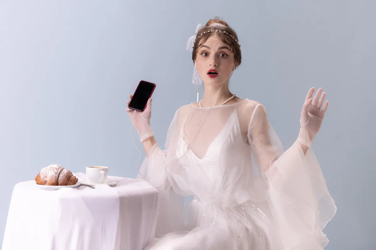 Retró stílusú fiatal nő, telefonnal a kezében a személyiségtesztben.