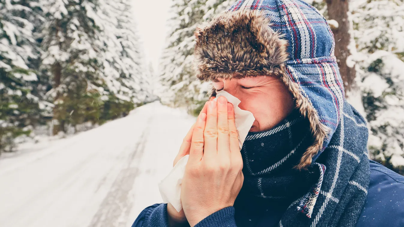 Orrot fújó férfi hideg időben a téli természetben