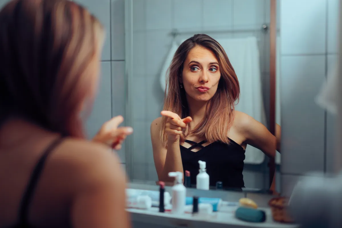 Egy nárcisztikus nő nézegeti magát a tükörben.