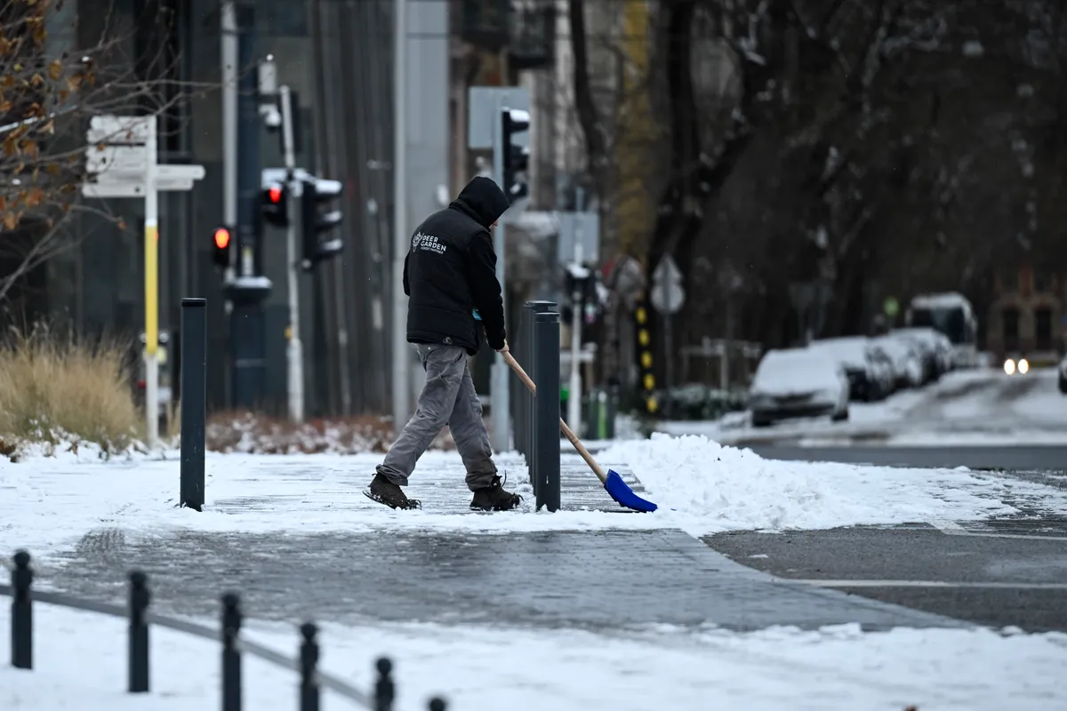 Havat lapátol egy férfi a behavazott Városligetben 2026. január 1-jén