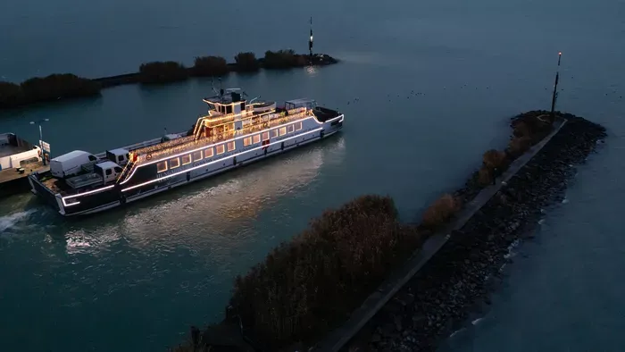 Ünnepi fényekben úszó komp szeli a habokat a Balatonon