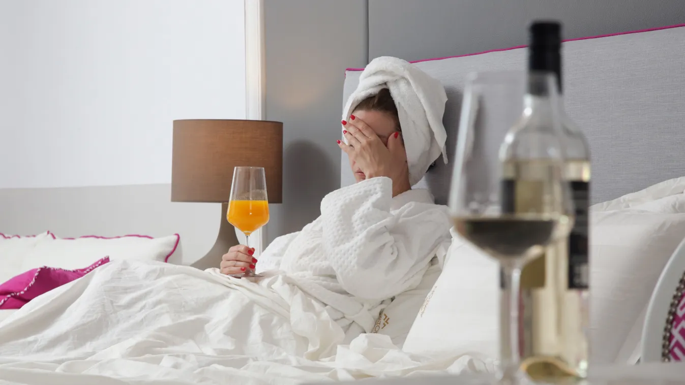 Az ágyban másnaposan fekvő nő, akinek magas volt az alkoholfogyasztása.
