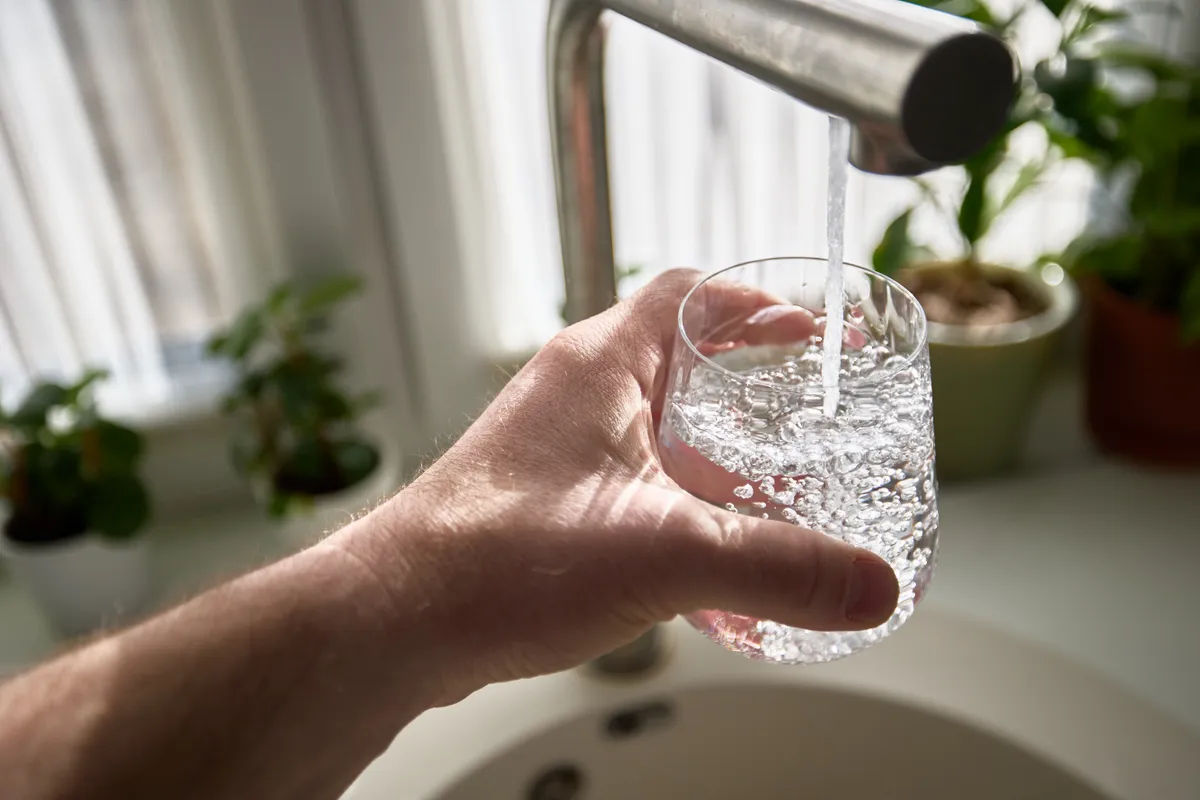 A pohárba vizet töltő férfi együttlét után.