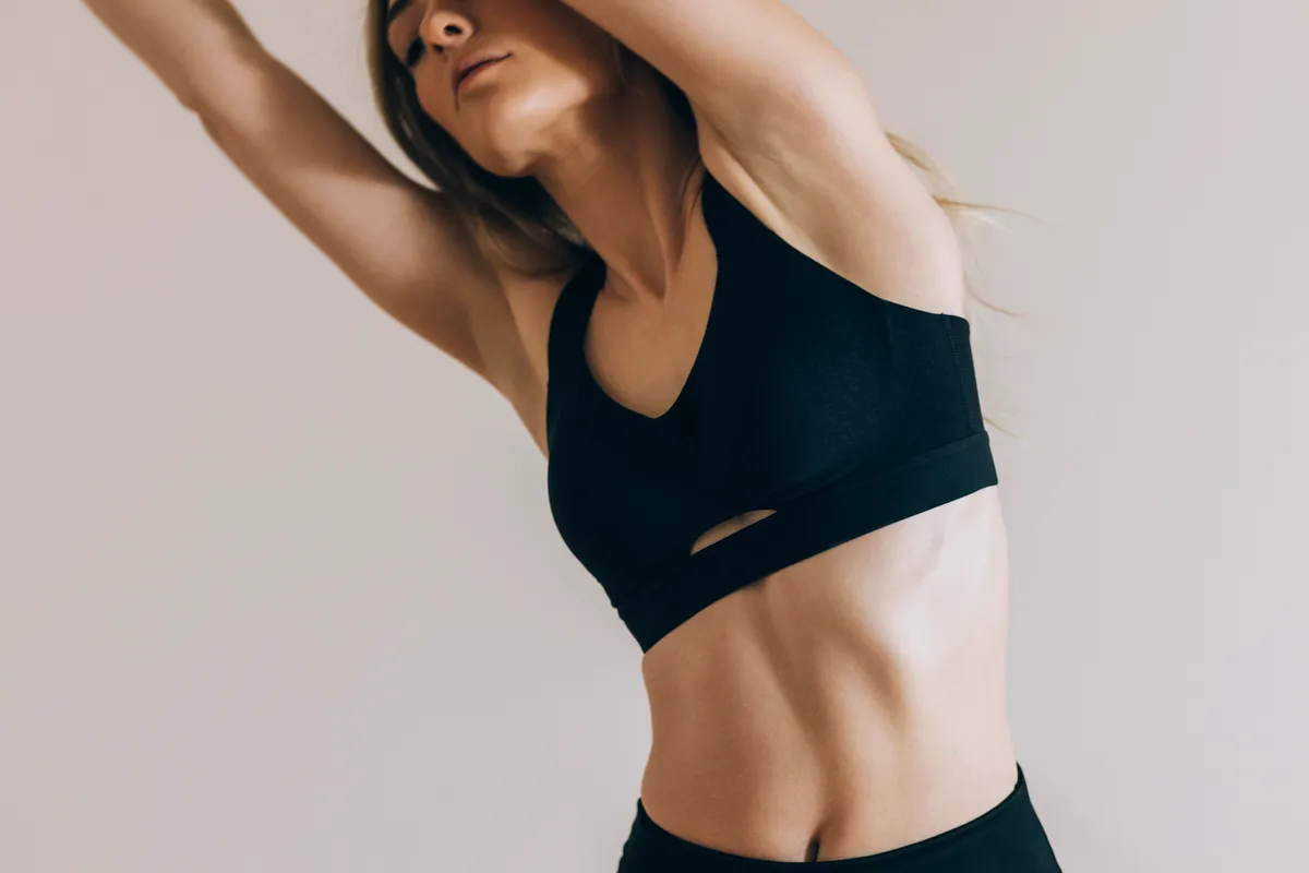 Lapos hasú fiatal nő, aki éppen nyújt.