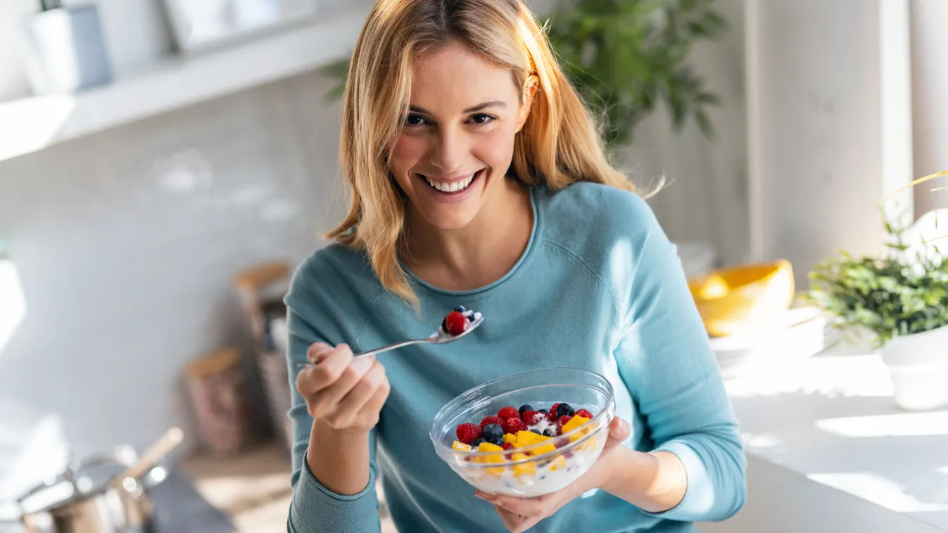 Bogyós gyümölcsöket reggeliző lány, akinek fontos a rákmegelőzés.