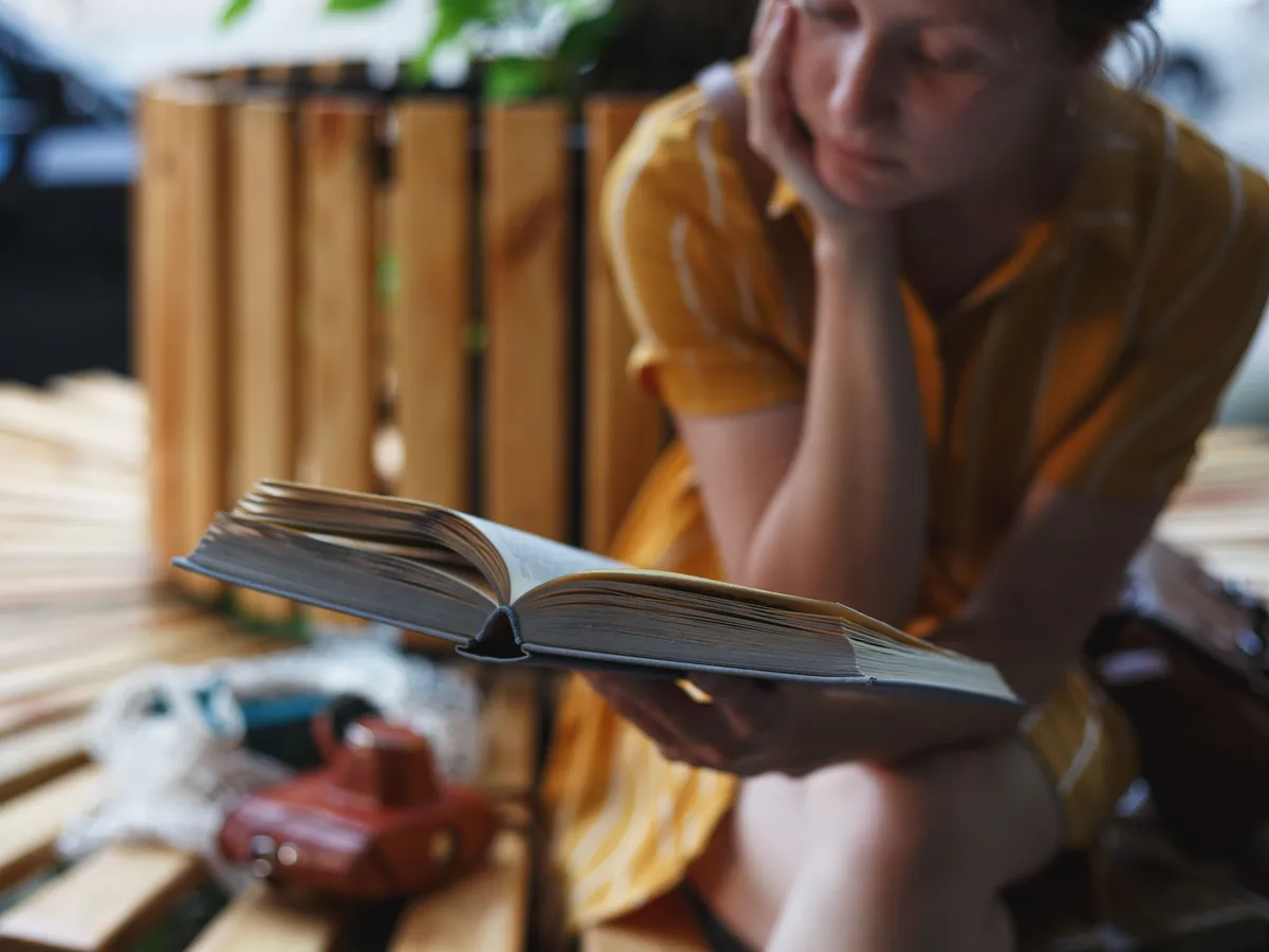 Irodalmat olvasó fiatal nő a kvízben.