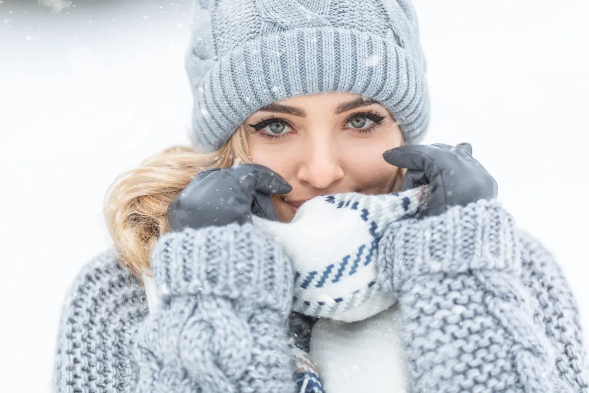 Fiatal nő sapkában és téli sminkben.