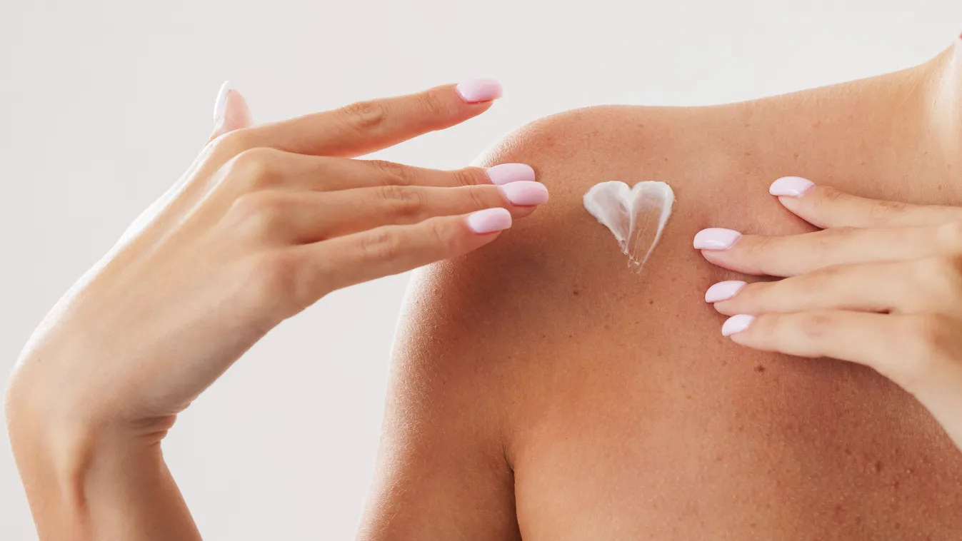 Téli bőrvédelem részeként a vállát krémező nő