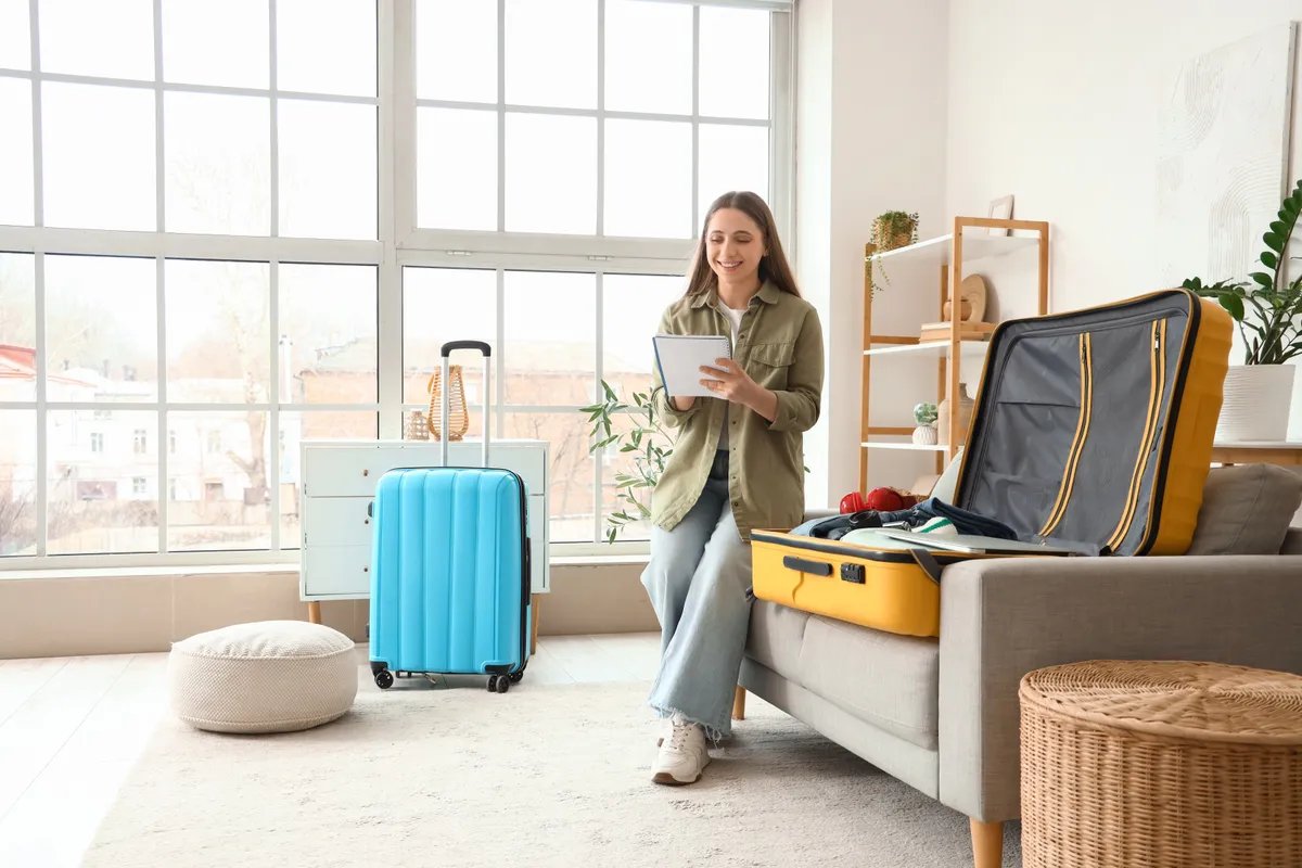 Fiatal nő kézipoggyászt pakol bőrönd helyett.