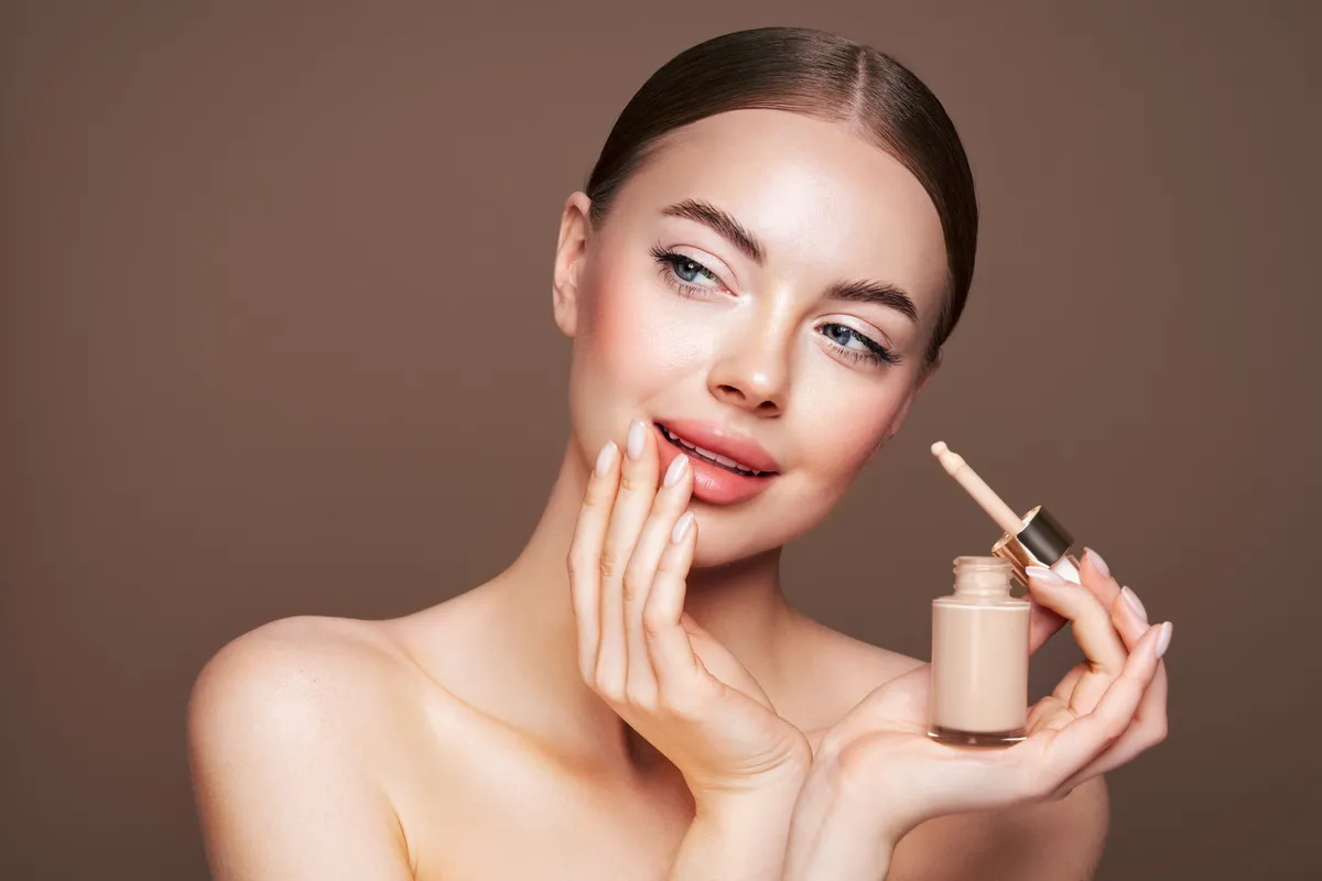 Fiatal nő alapozót használ