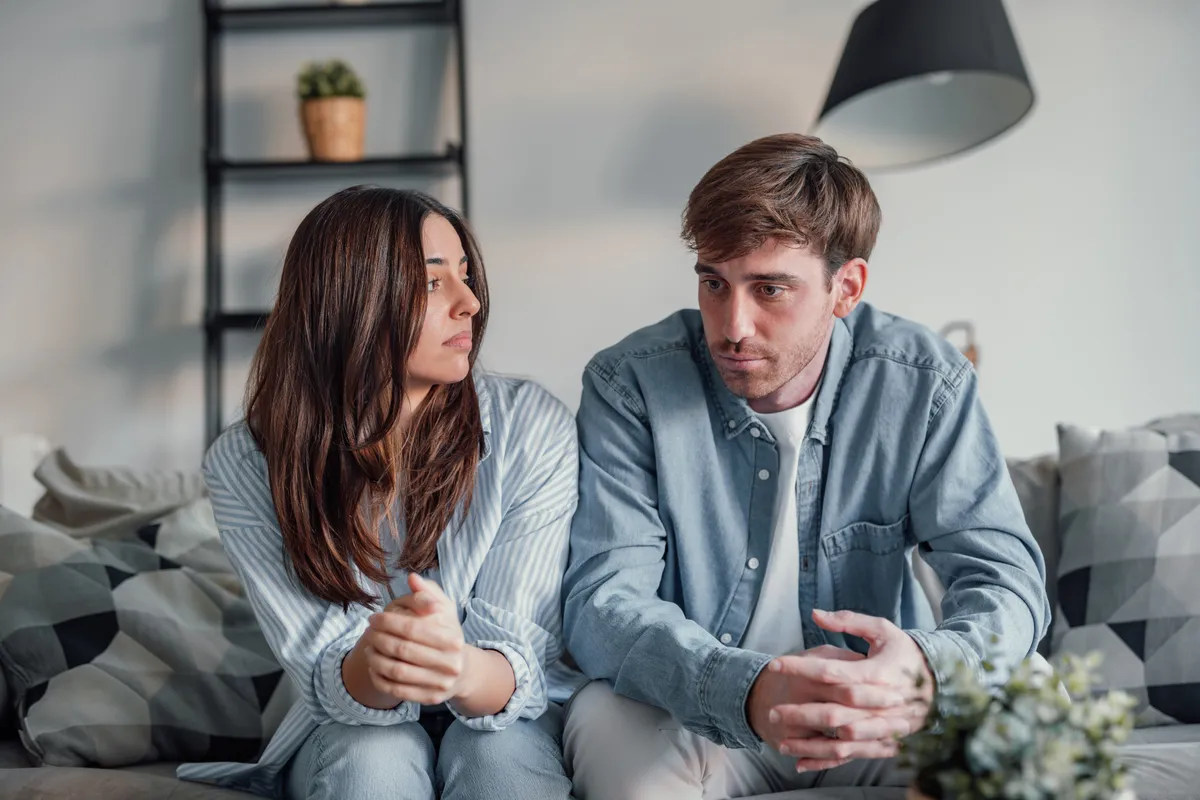 A nagy Ő-ről beszélgető gondterhelt pár ül a kanapén.