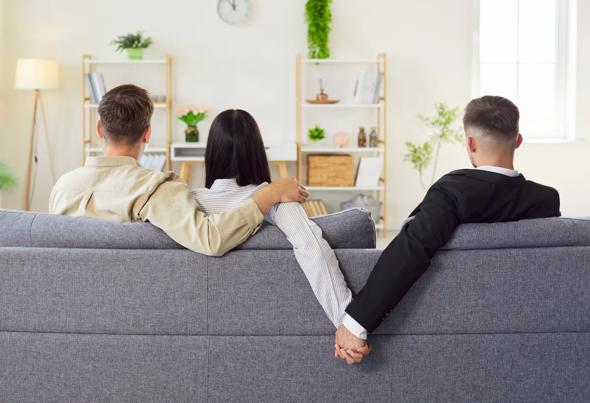 Kanapén ülő pár, a férfinak fel sem tűnik, hogy megcsalás áldozata.