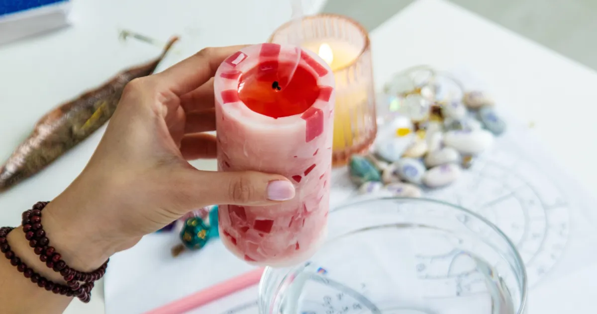 Újévi mágikus rituáléhoz való gyertyát tart egy női kéz. 