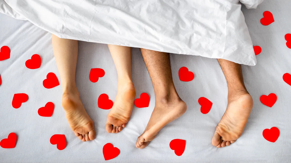 Egy pár fekszik Valentin-napon az ágyban.