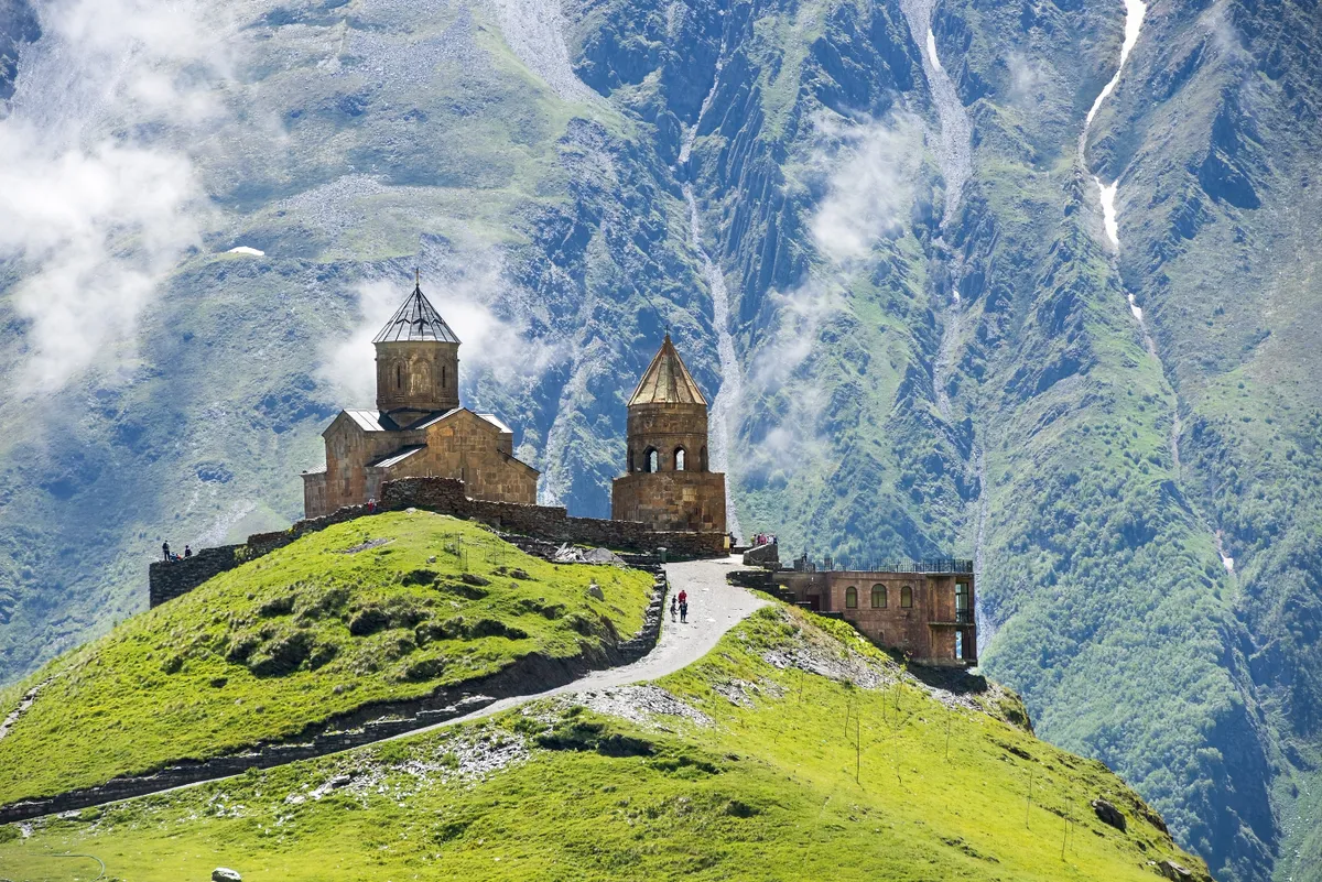 A grúziai Kazbegi panorámája a Gergeti Szentháromság-templommal.