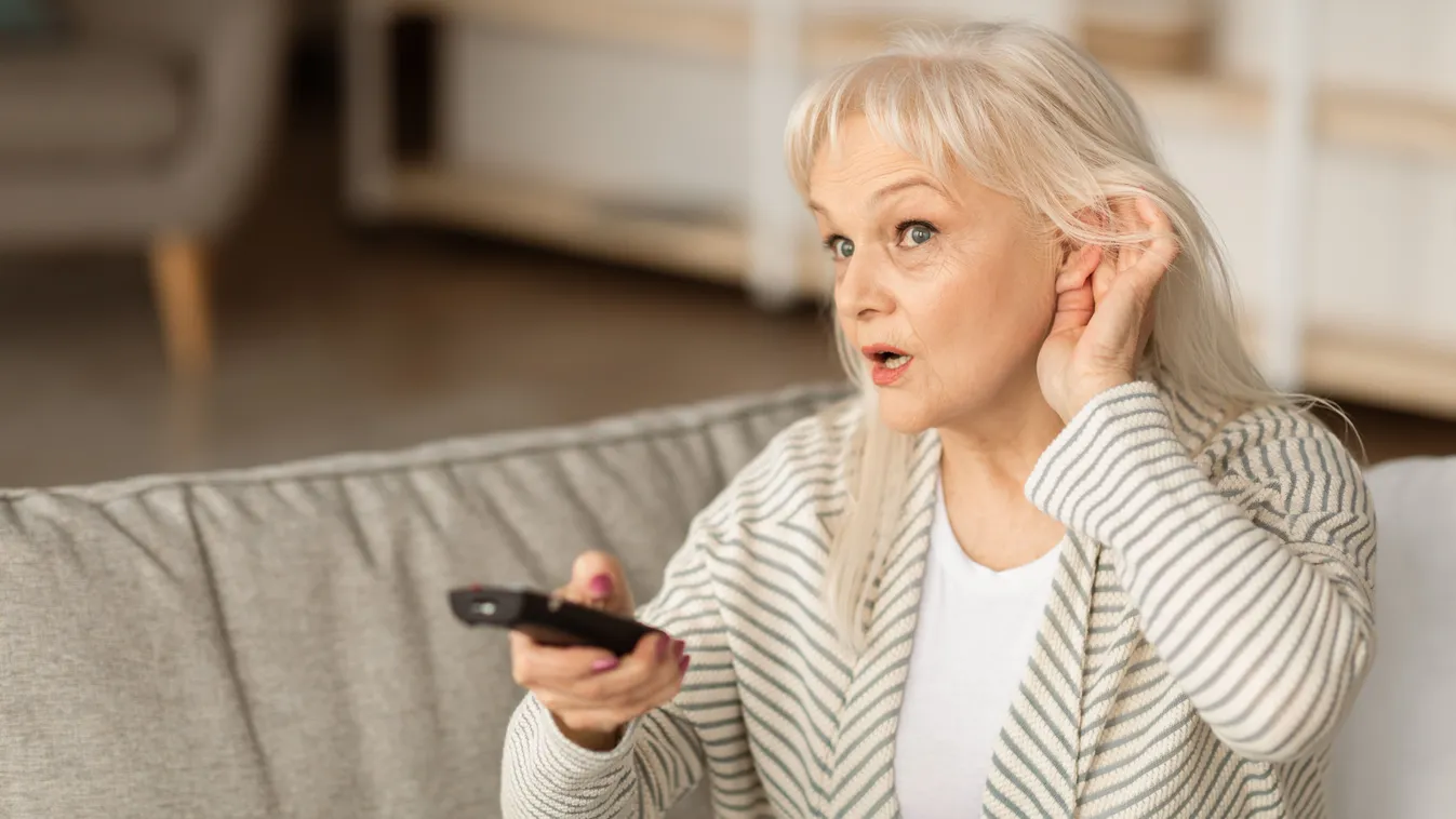 Idős nő a halláskárosodás korai jelei miatt nem hallja a TV-t